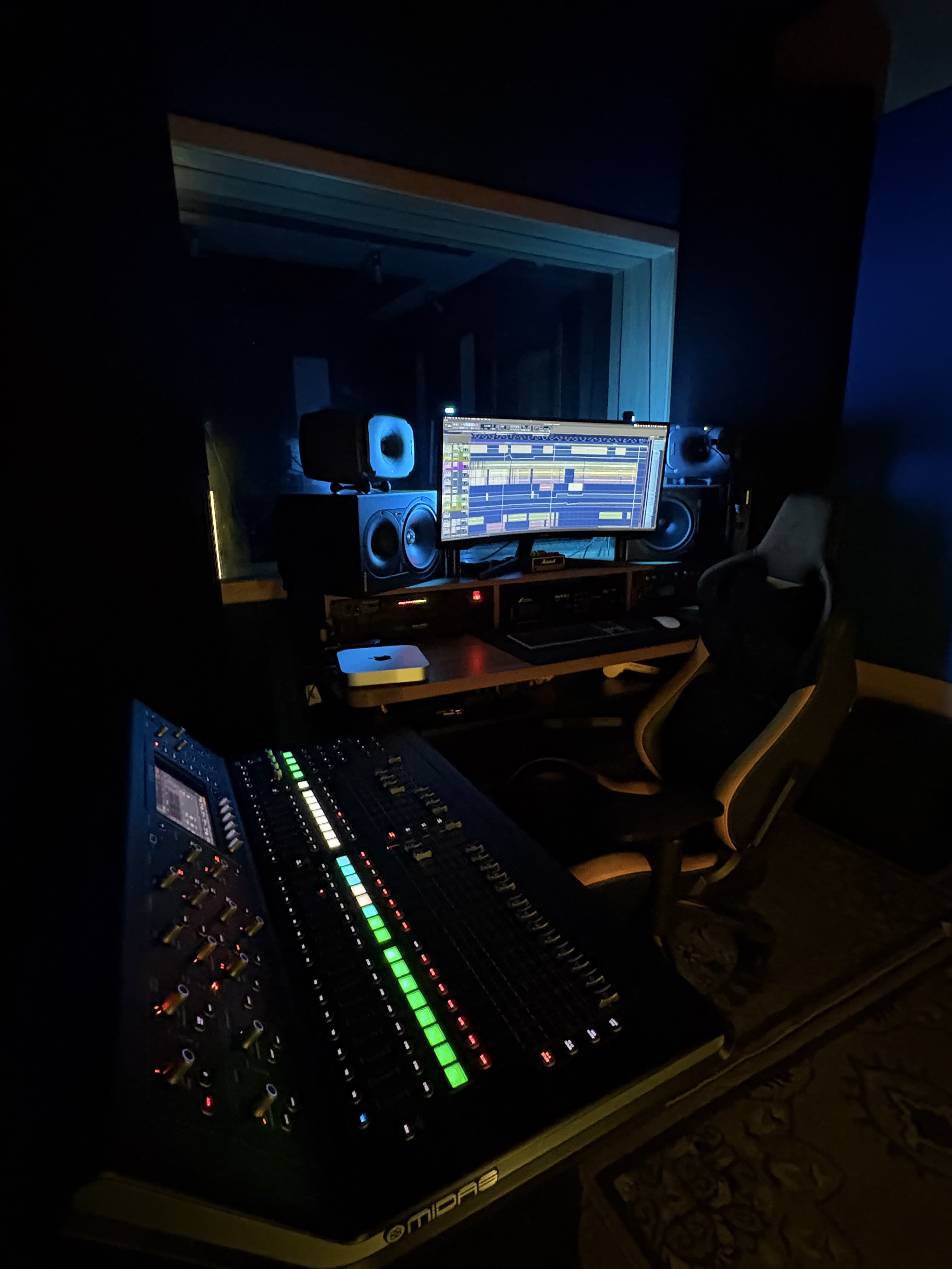 Wide shot of the studio's control room with mixing desk and monitors.